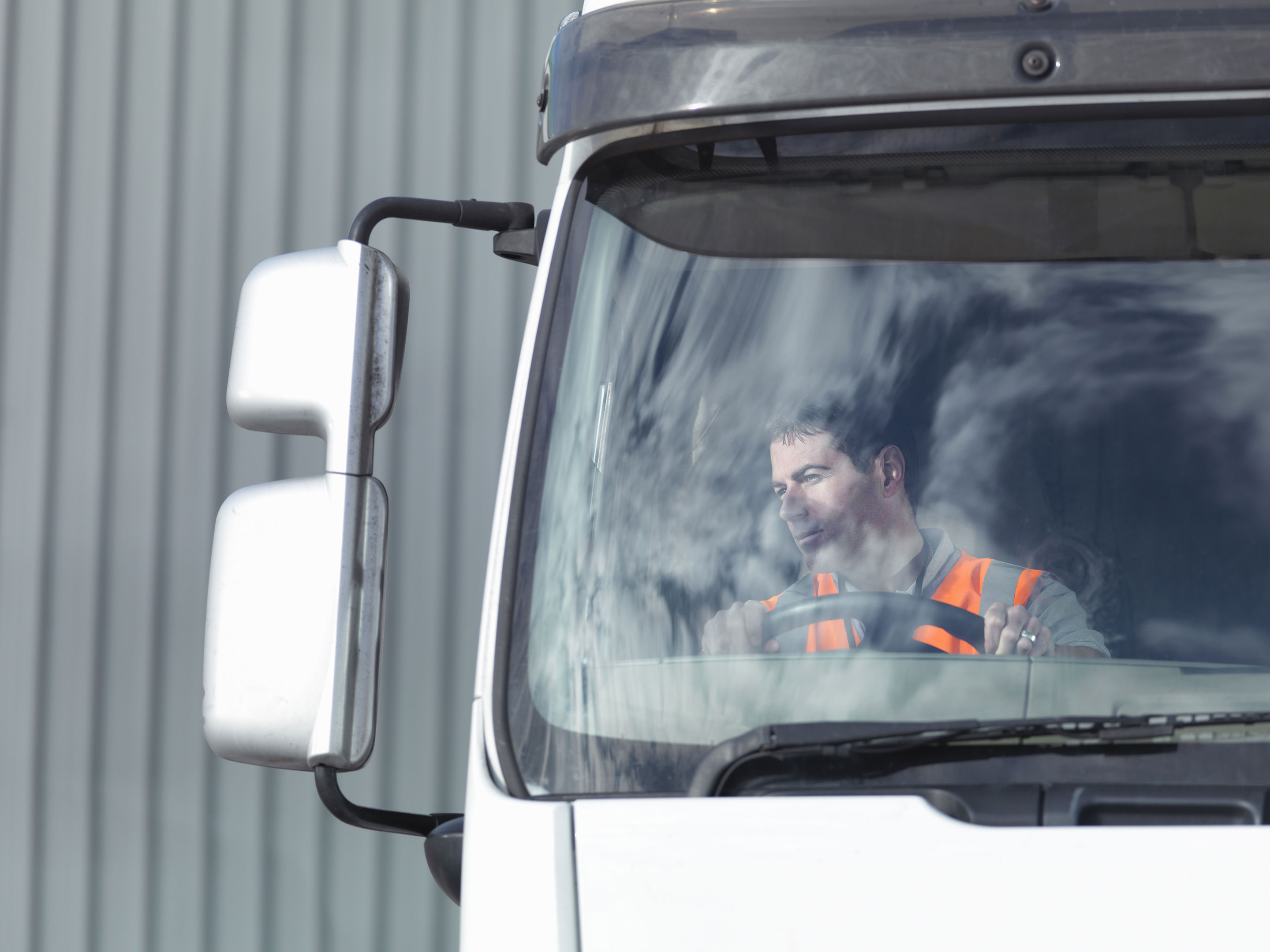 Truck Driver Looking At Side View Mirror