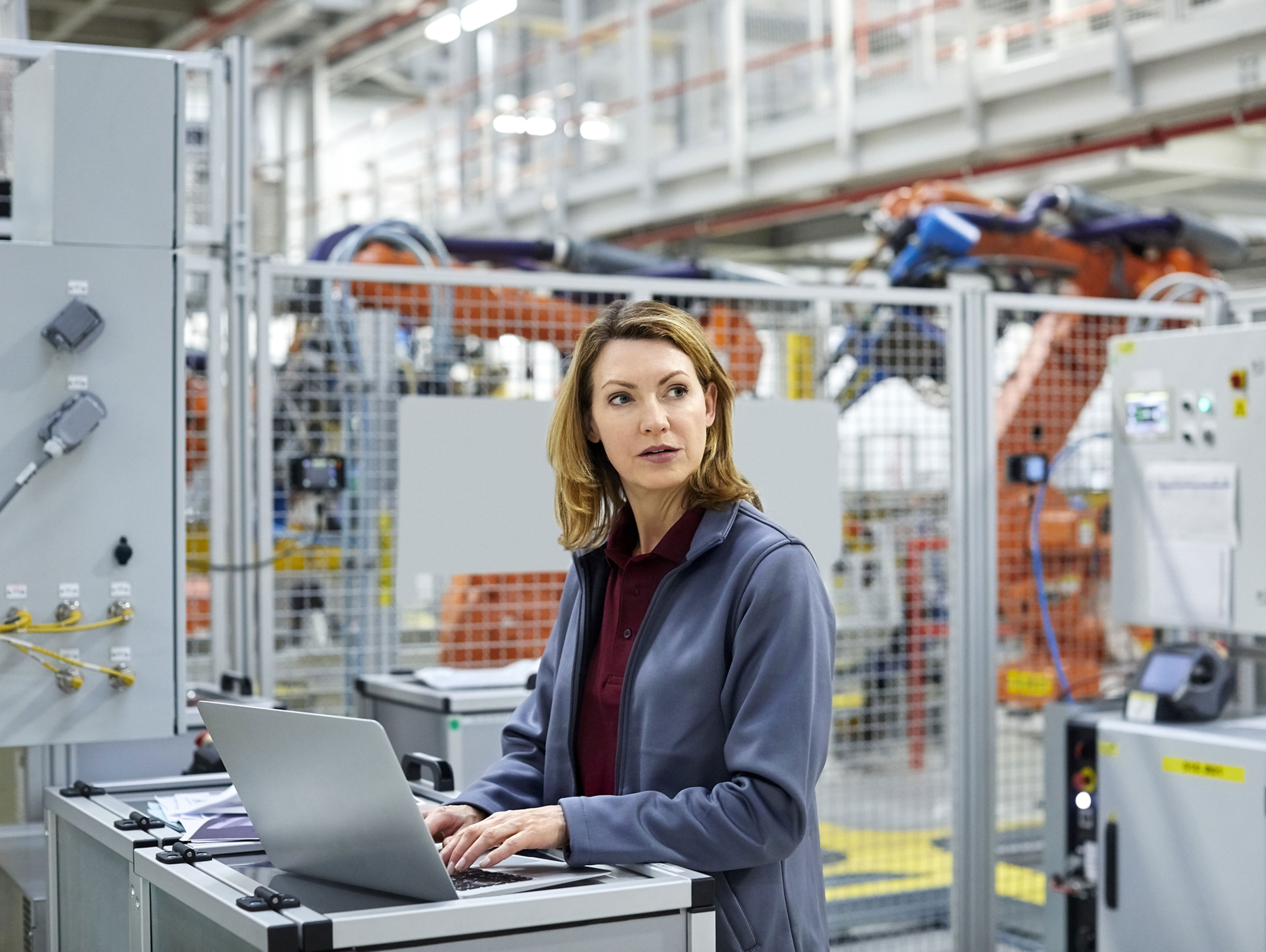 A picture of a woman working at a laptop in a distribution centre