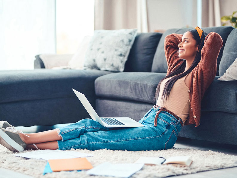 Lady On Laptop Leaning Against Sofa