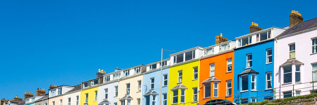 A row of colourful terraced houses, including bright yellow, orange and blue facades.