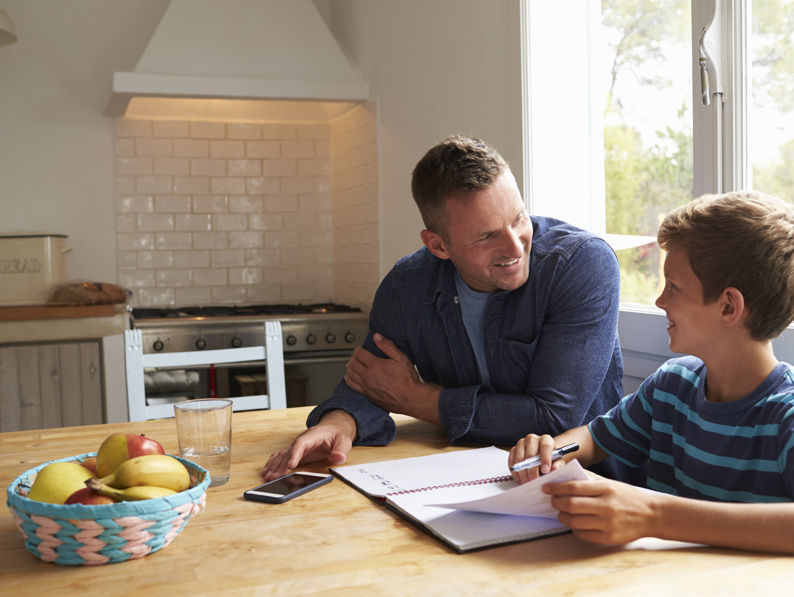 Father And Son Looking At Notebook