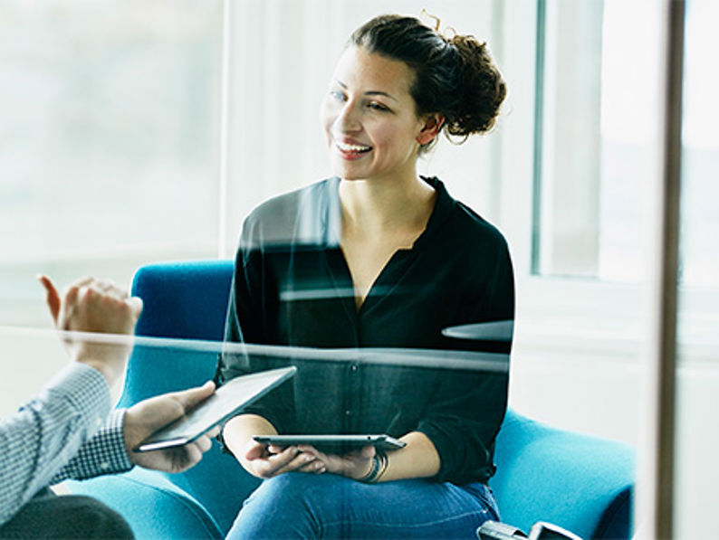 Two Colleagues Discussing Project On Digital Tablets