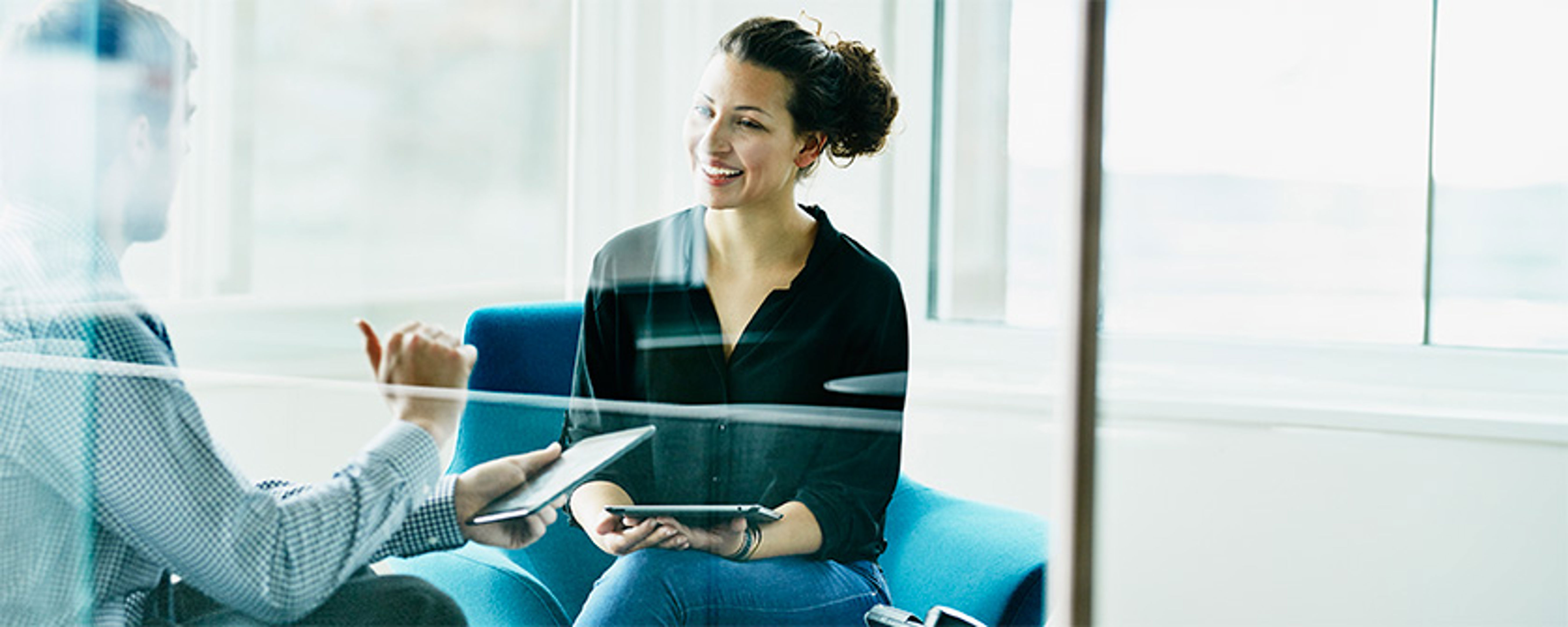 Two Colleagues Discussing Project On Digital Tablets