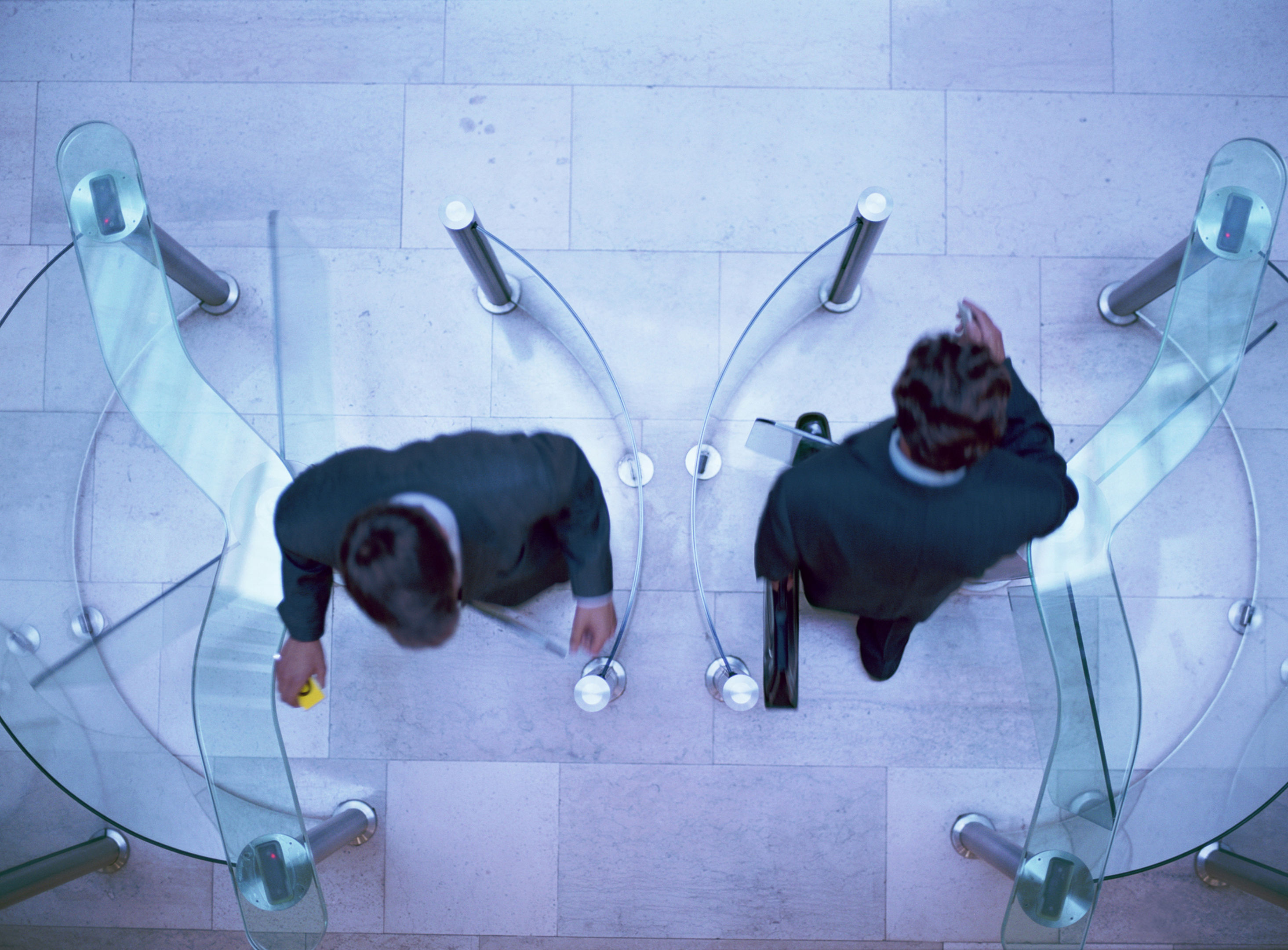 Two businessmen entering and exiting an office