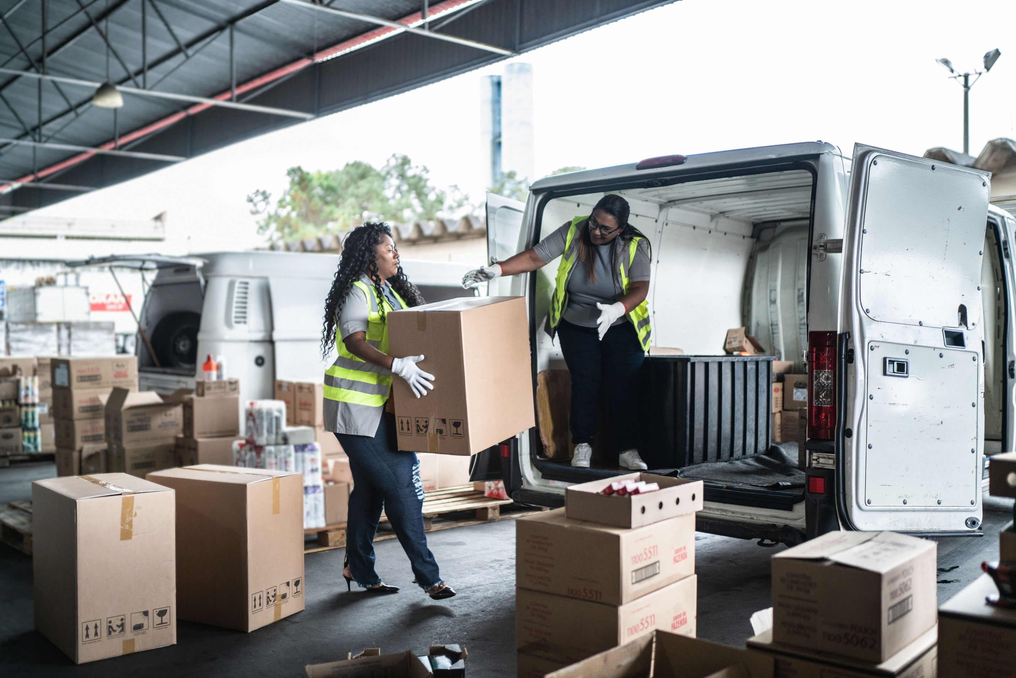 Warehouse workers loading van with boxes