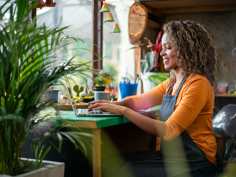 Woman Working On A Laptop At Her Flower Shop