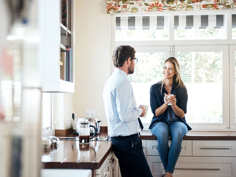 Two People Chatting In A Kitchen