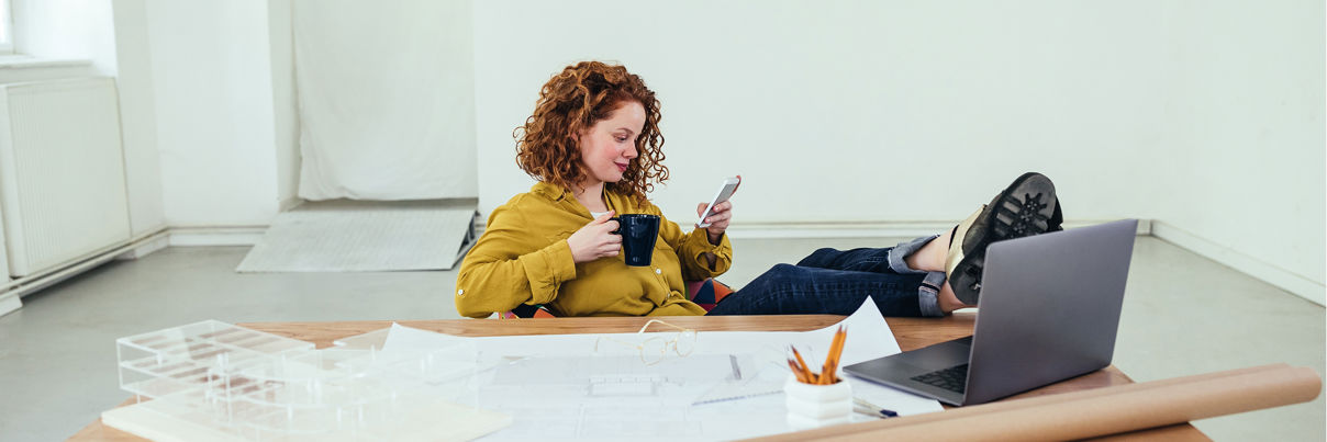 Architect Using Phone At Her Workplace