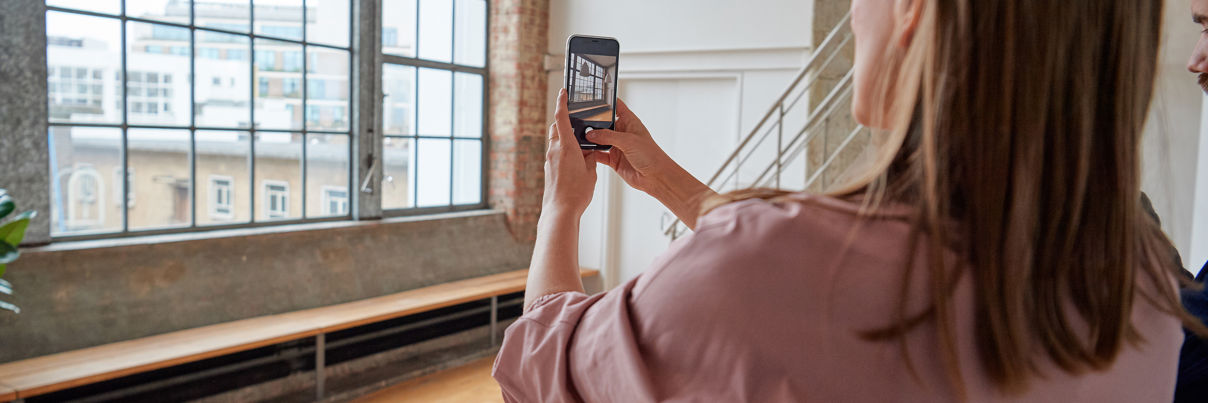 Male And Female Taking Photographs Of Their New Apartment