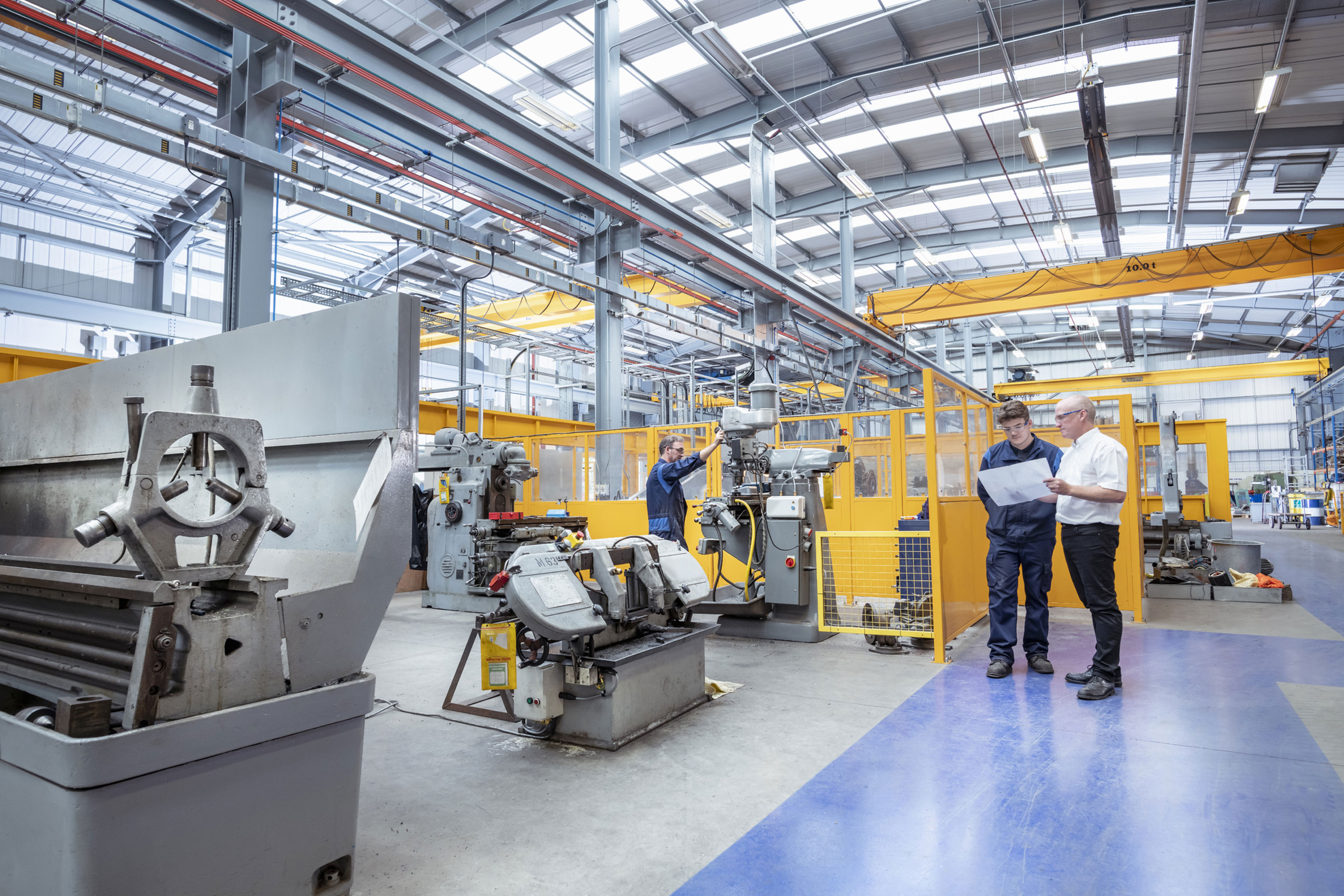 Three engineers working at a plant and discussing plans