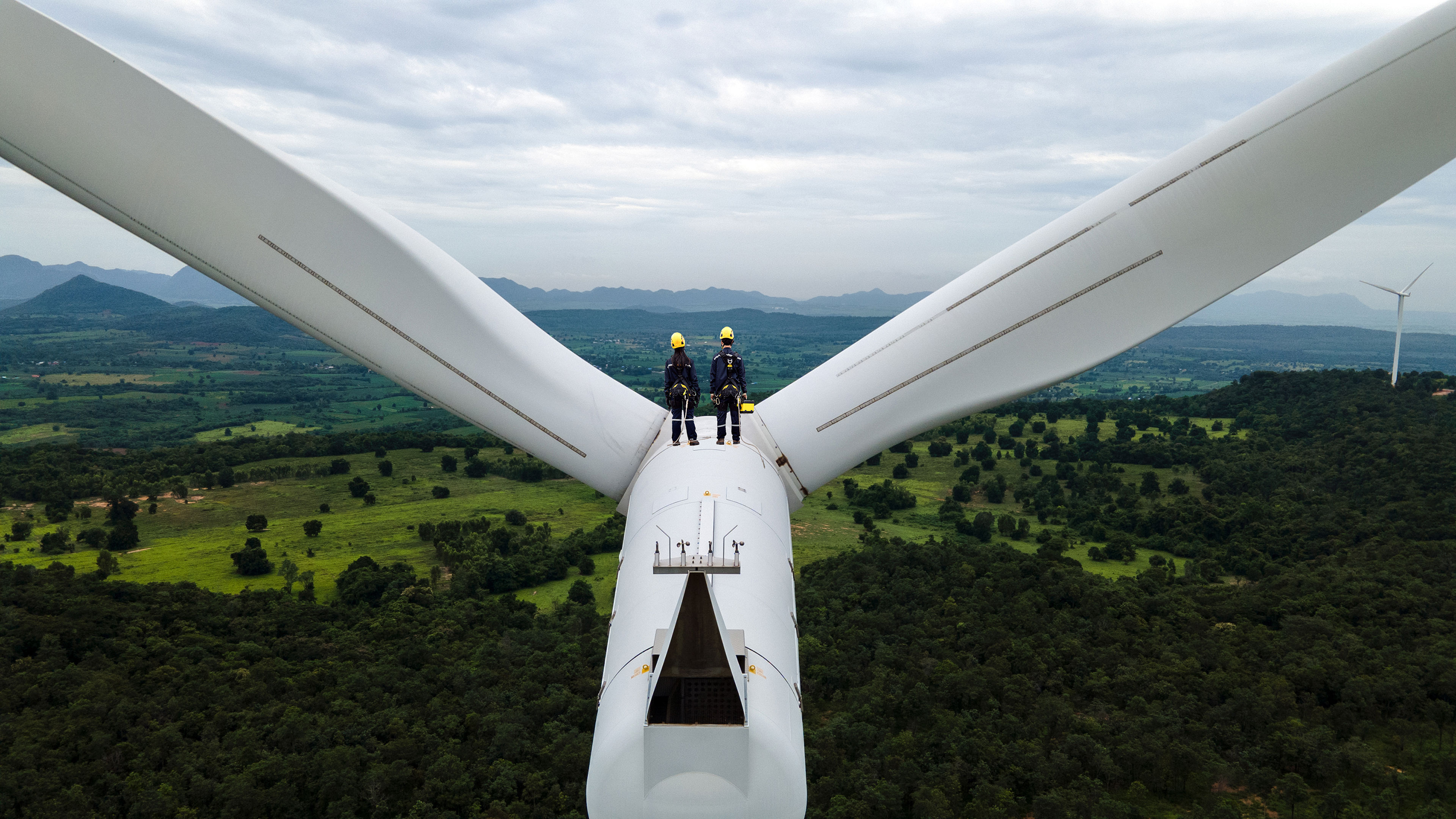 Two Electric Engineers On Top Of Wind Turbine