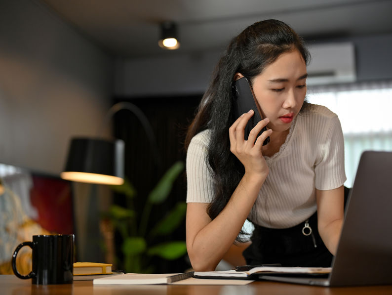 Lady Concentrates On Talking On The Phone With Her Client In The Office