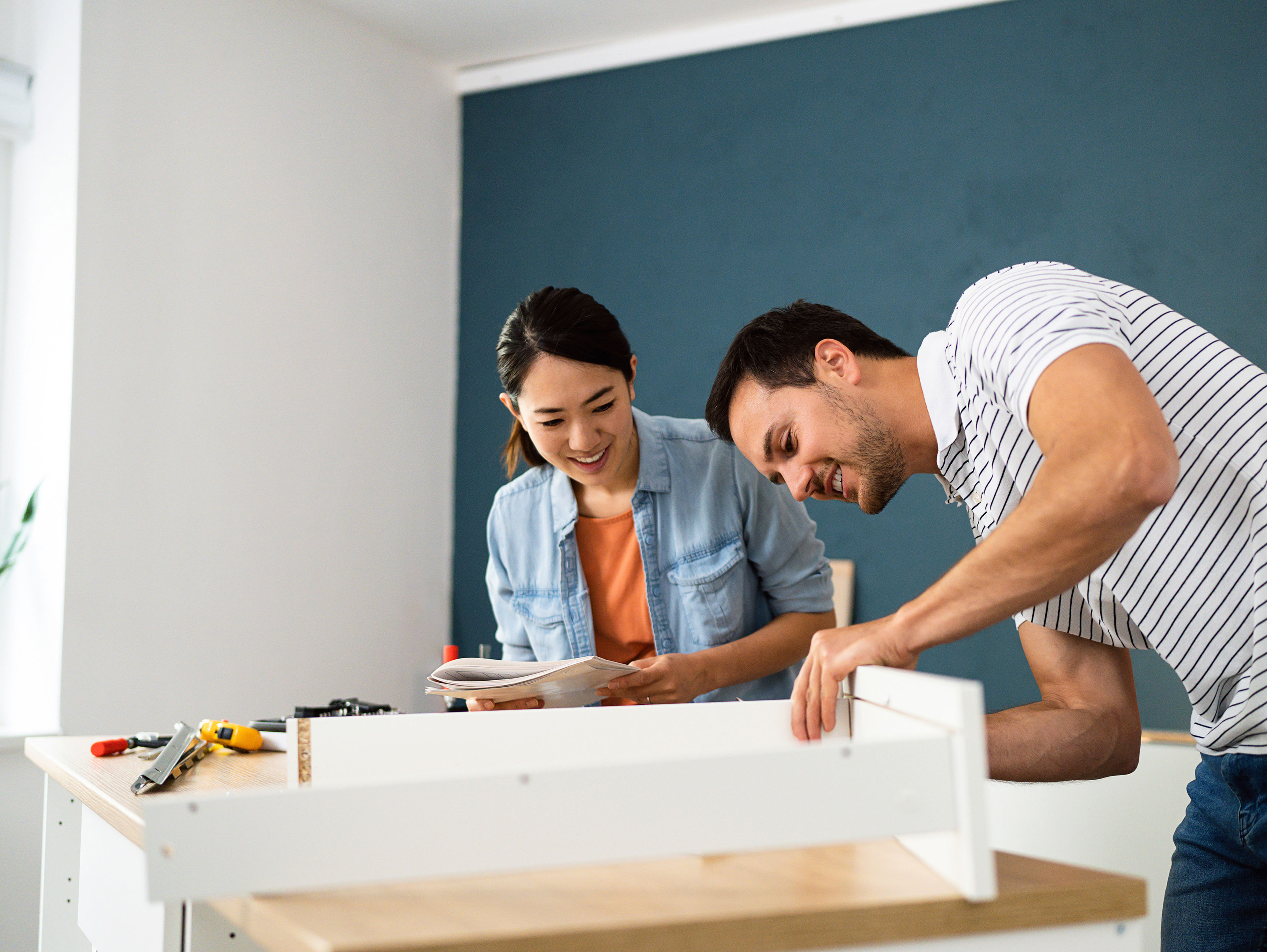 Couple Assembling Furniture Together At Their New Apartment