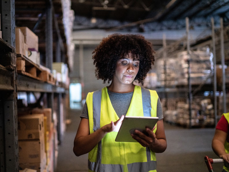 Woman Using The Digital Tablet In A Warehouse