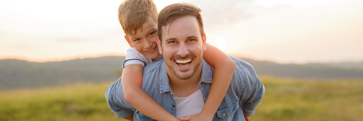 Father Standing And Holding A Toddler Son