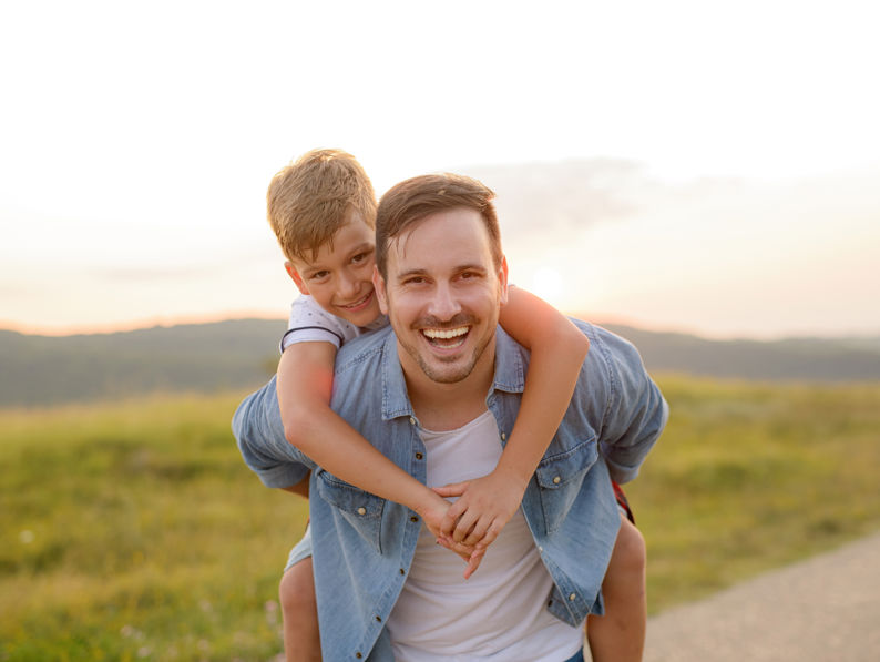 Father Standing And Holding A Toddler Son