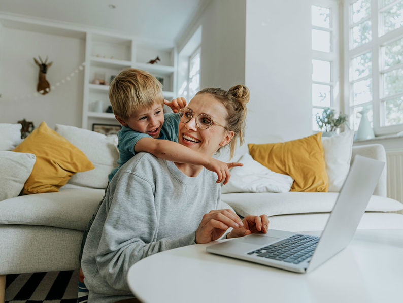 Mum With Blonde Haired Son Pointing At Laptop