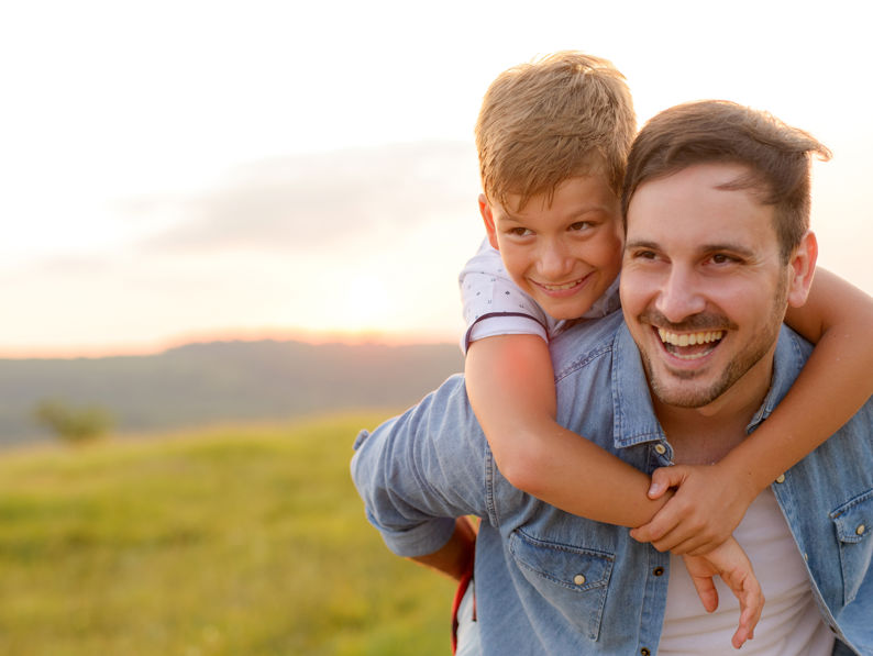 Father Standing And Holding His Son