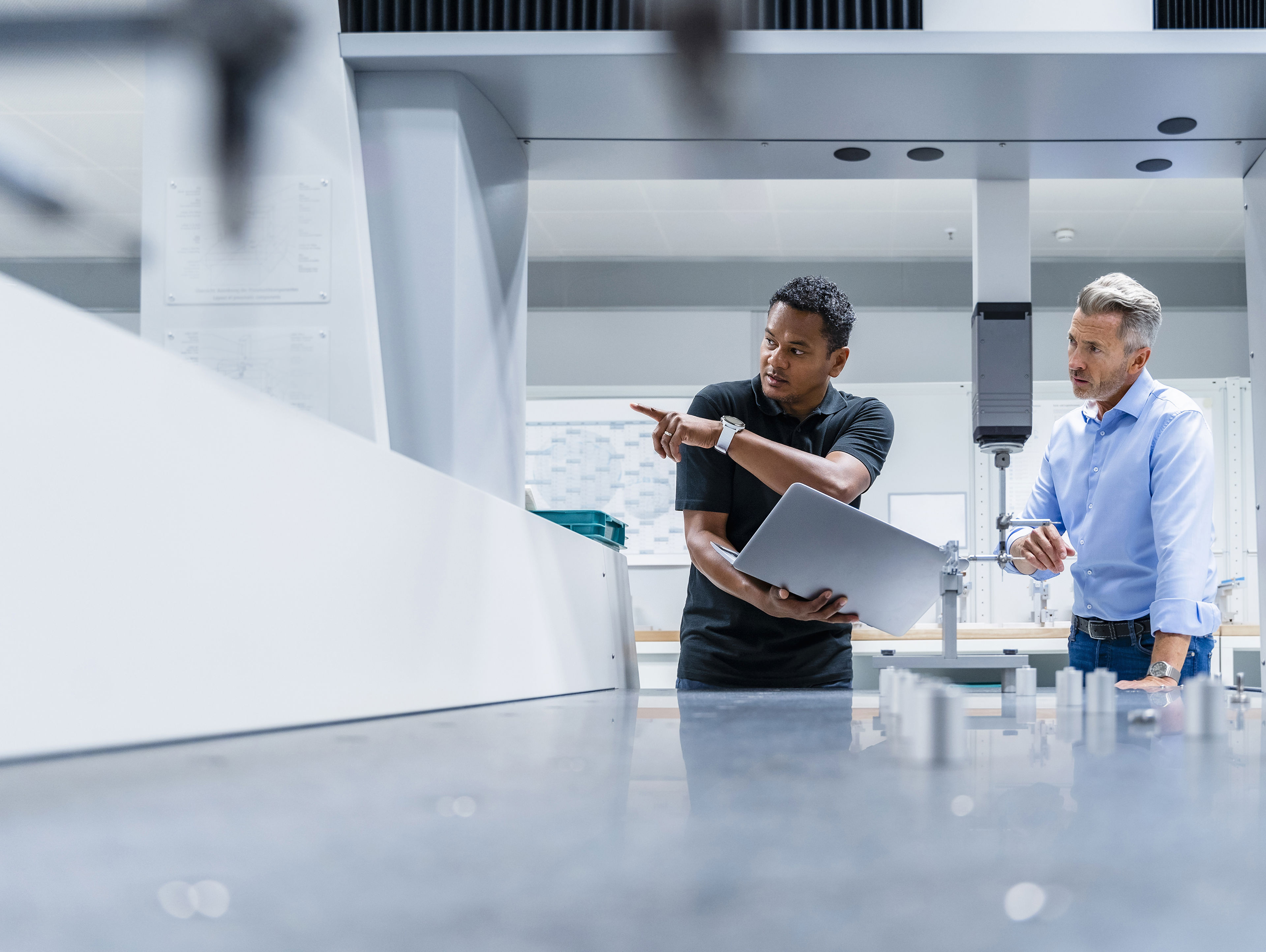 Engineer With Laptop Pointing By Businessman At Factory