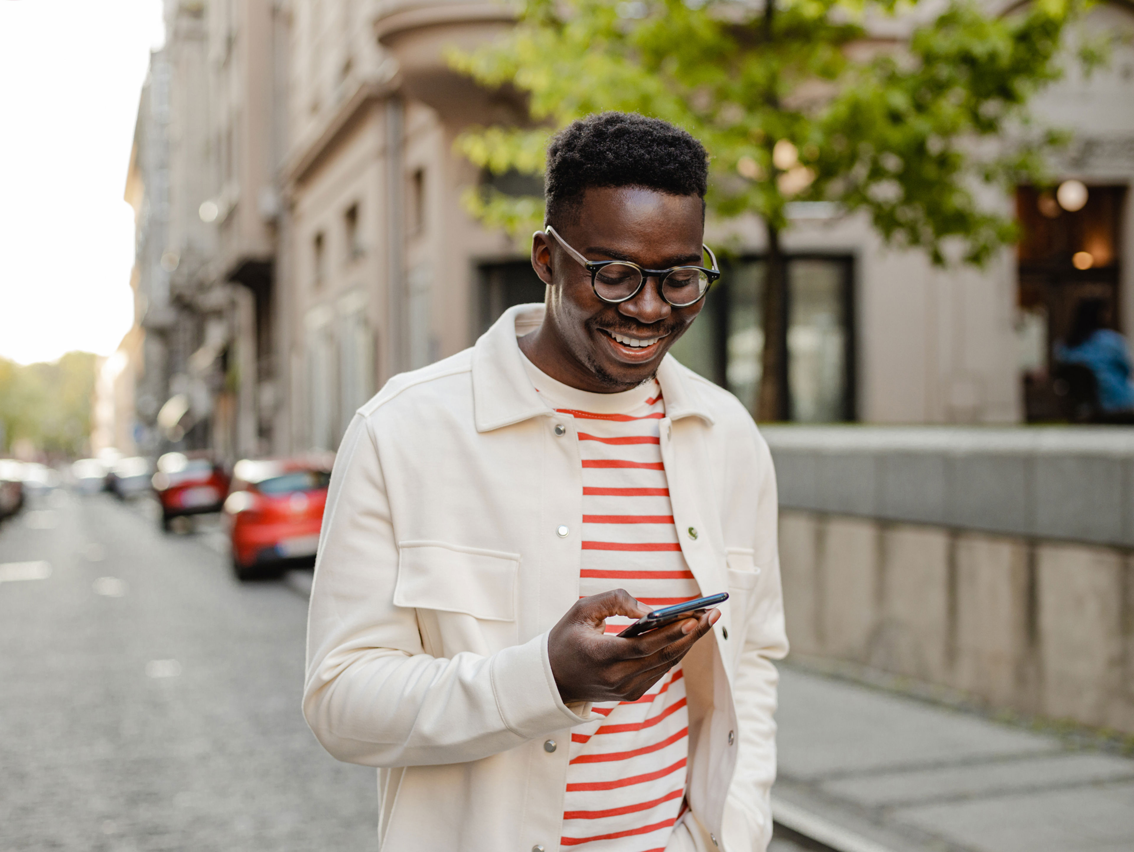 Young man walking outside scrolling his phone