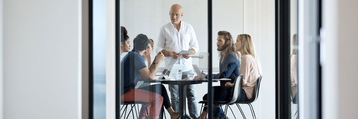 Entrepreneur Discussing With Colleagues At Office