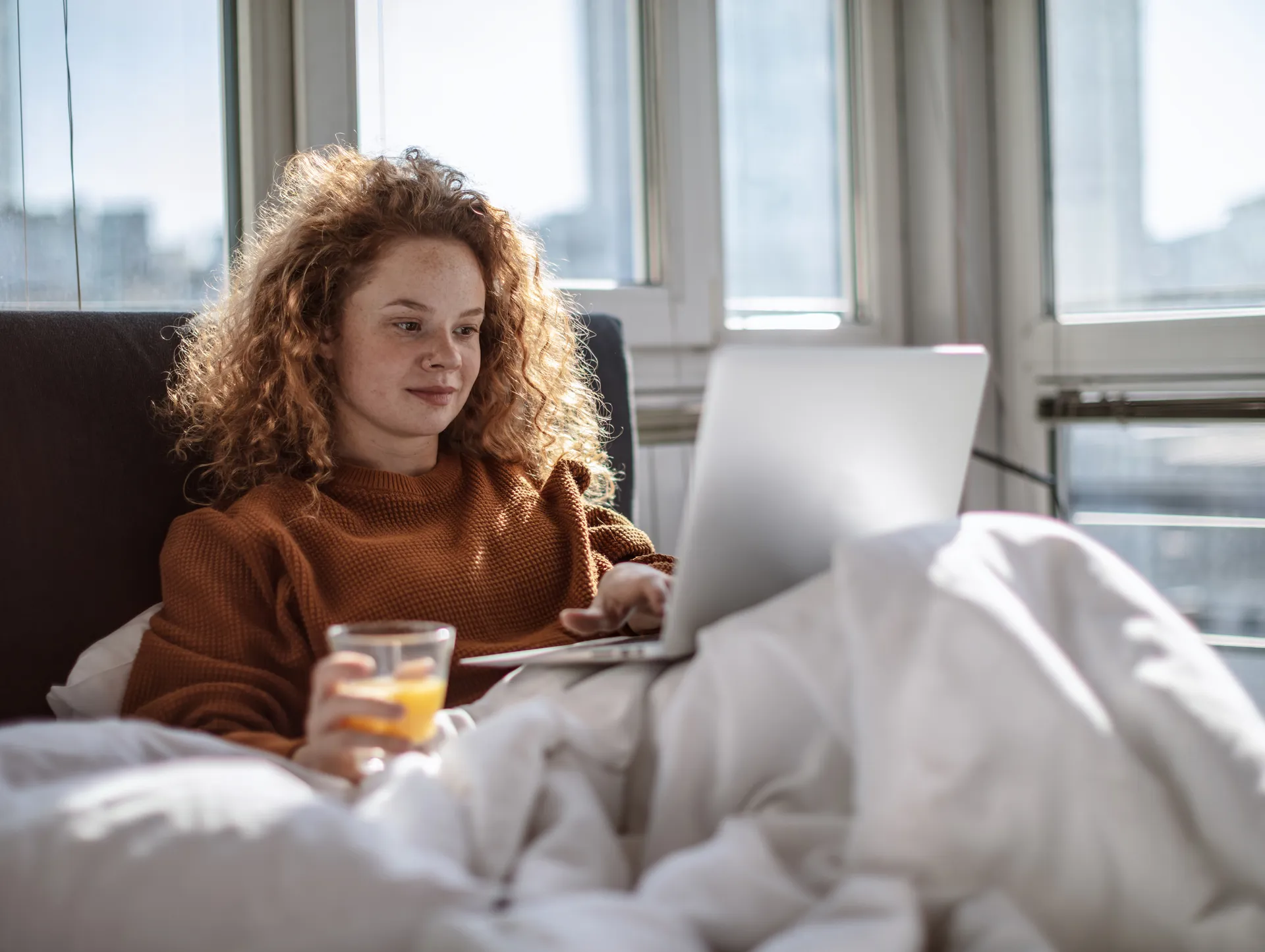 Young Woman Reading Morning News On Laptop